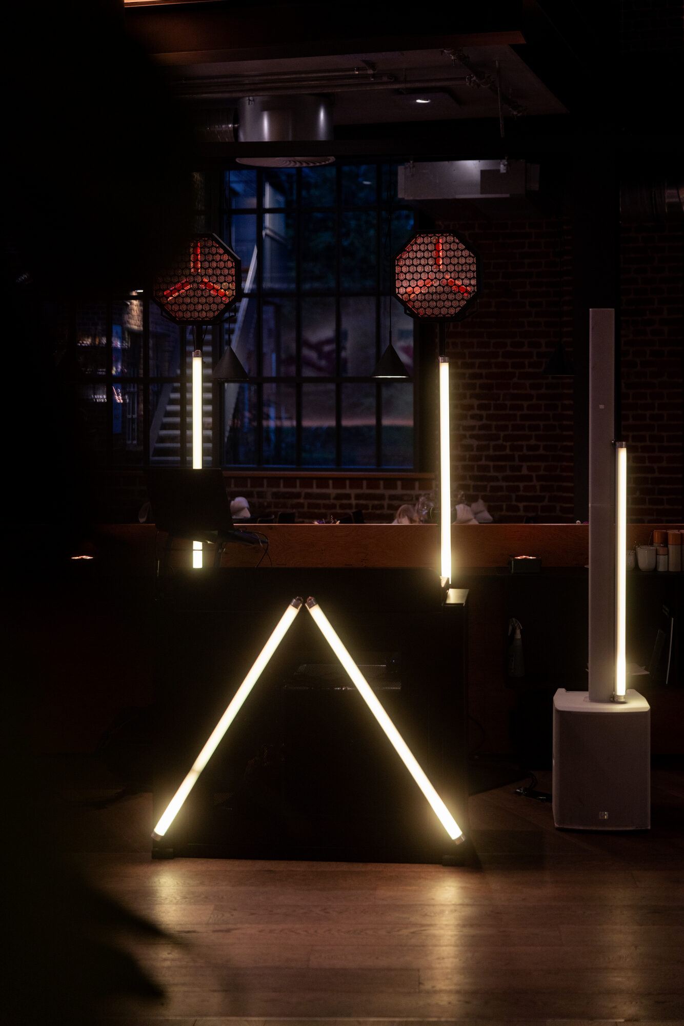 DJ Setup mit warmweißen Lichtsäulen vor den Fenstern des Lokschuppen Marburg
