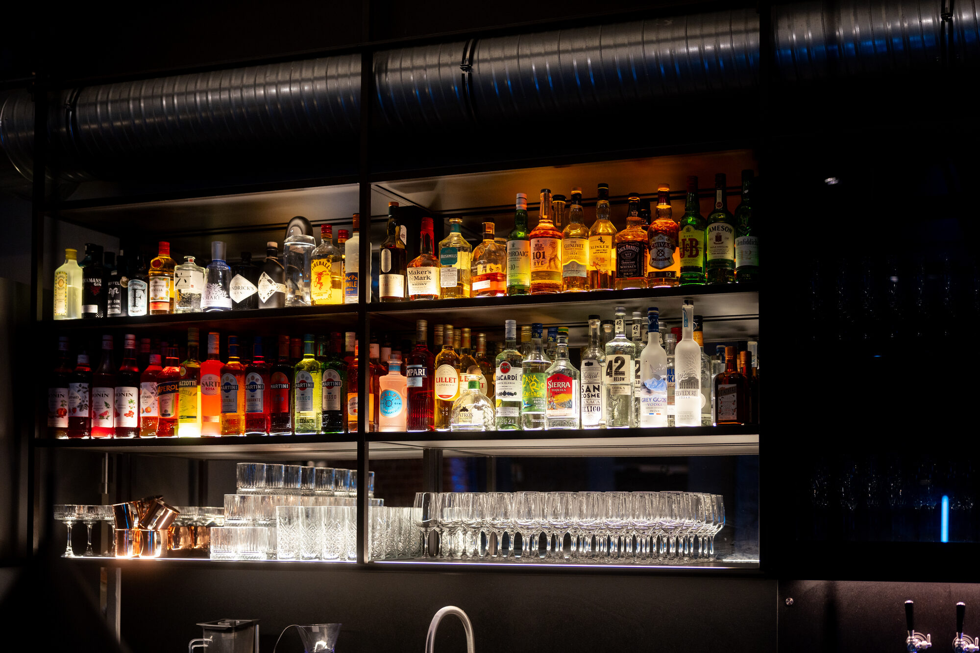 Beleuchtete Bar mit Flaschenregal im Lokschuppen Marburg