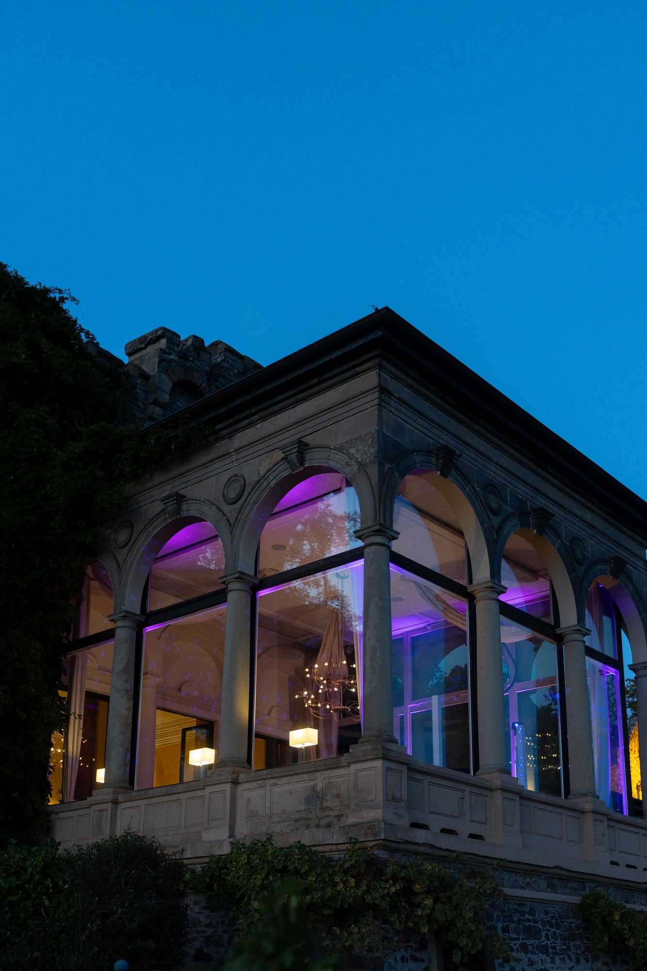 Pavillon von Burg Schwarzenstein bei Nacht mit beleuchteten Bogenfenstern