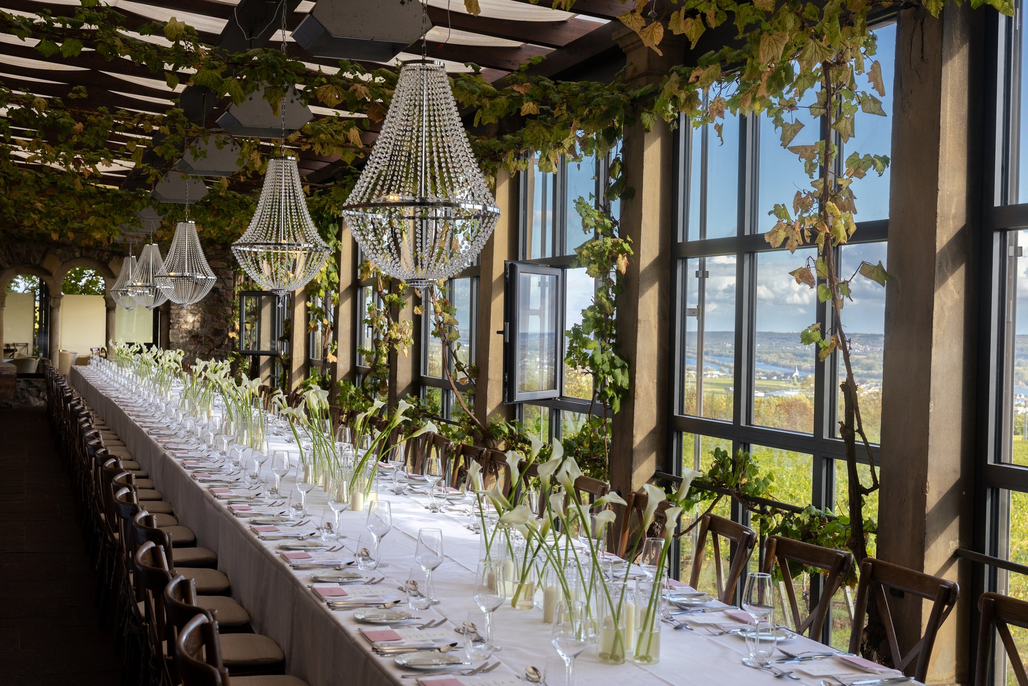 Lange Hochzeitstafel an der Glasfront mit Blick ins Rheingau
