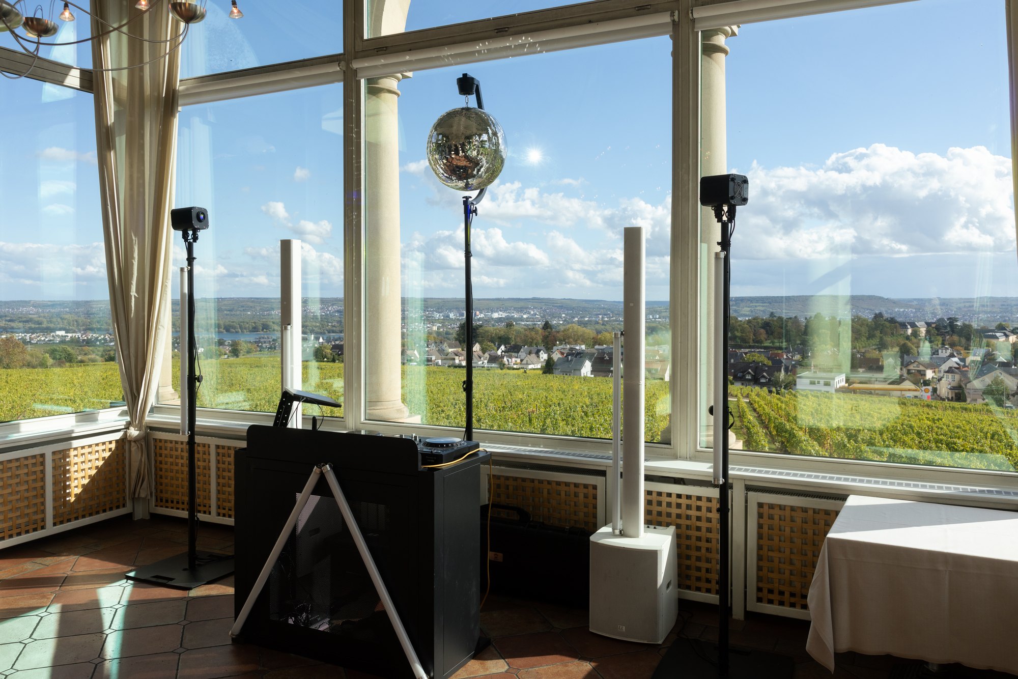 DJ Setup mit Lautsprechern und Discokugel vor dem Panorama des Rheingaus