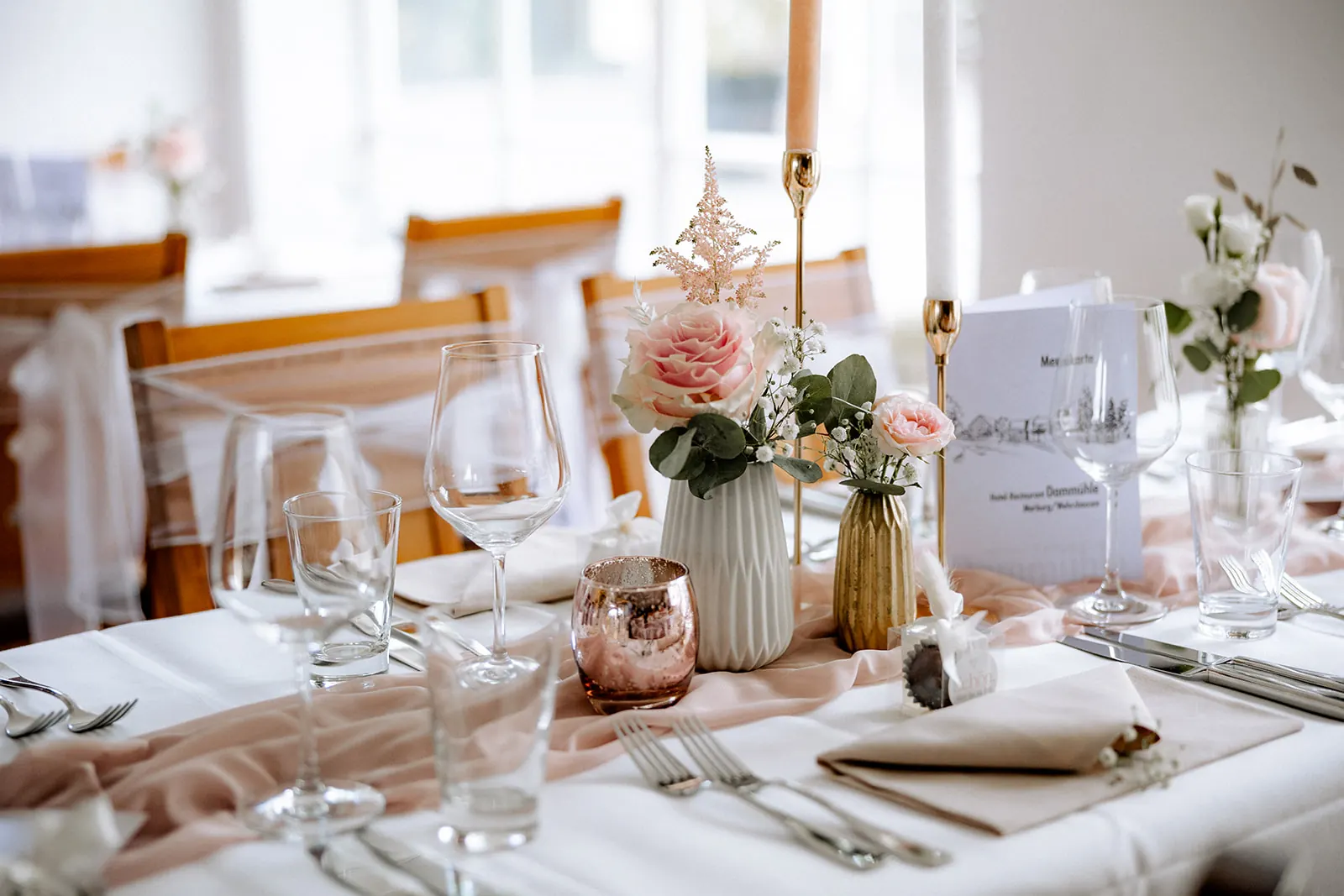 Eingedeckte Hochzeitstafel mit rosa Rosen und goldener Deko in der Dammühle