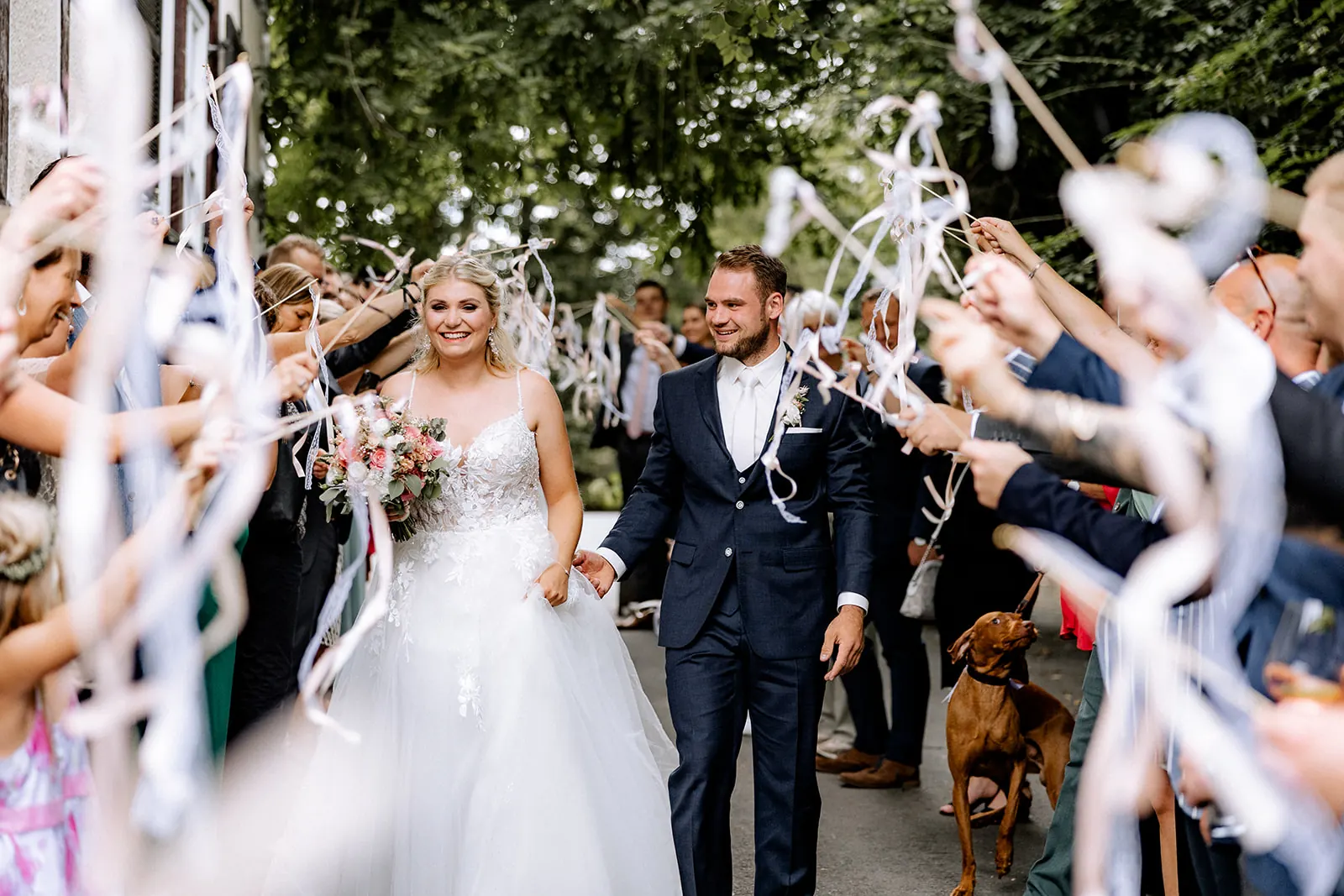 Brautpaar zieht zwischen Gästen mit Wedding Wands in die Dammühle ein