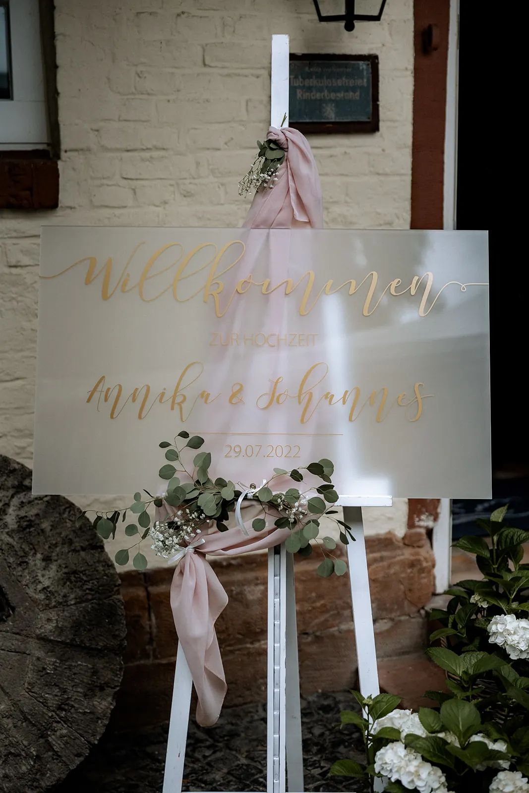 Willkommensschild mit Blumen am Eingang der Dammühle