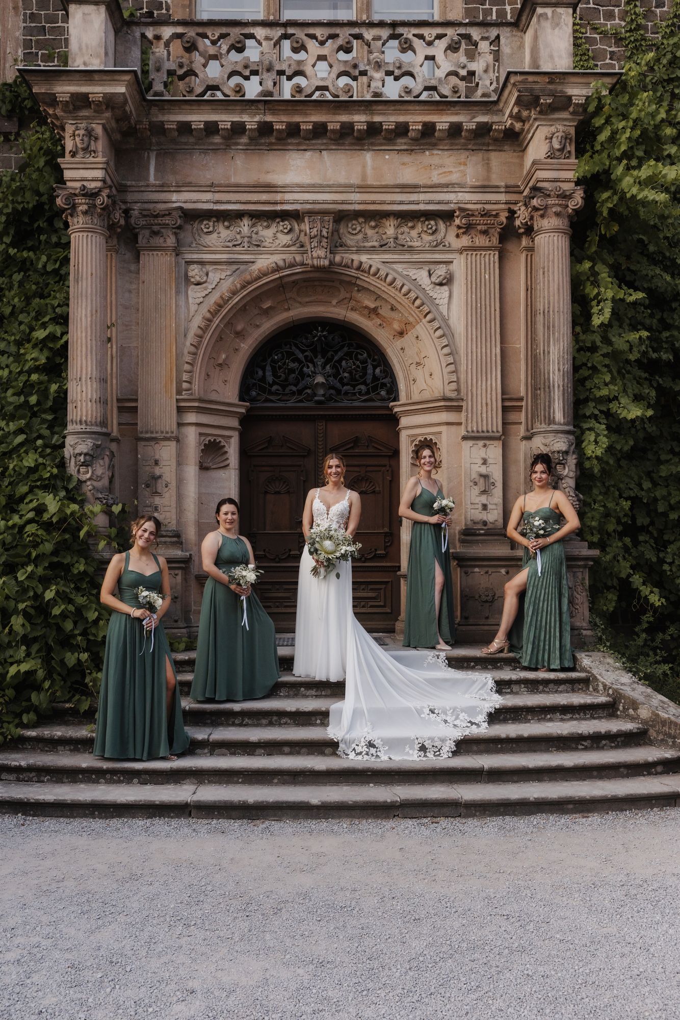 Bride with bridesmaids on the grand castle stairs of Schloss Rauischholzhausen