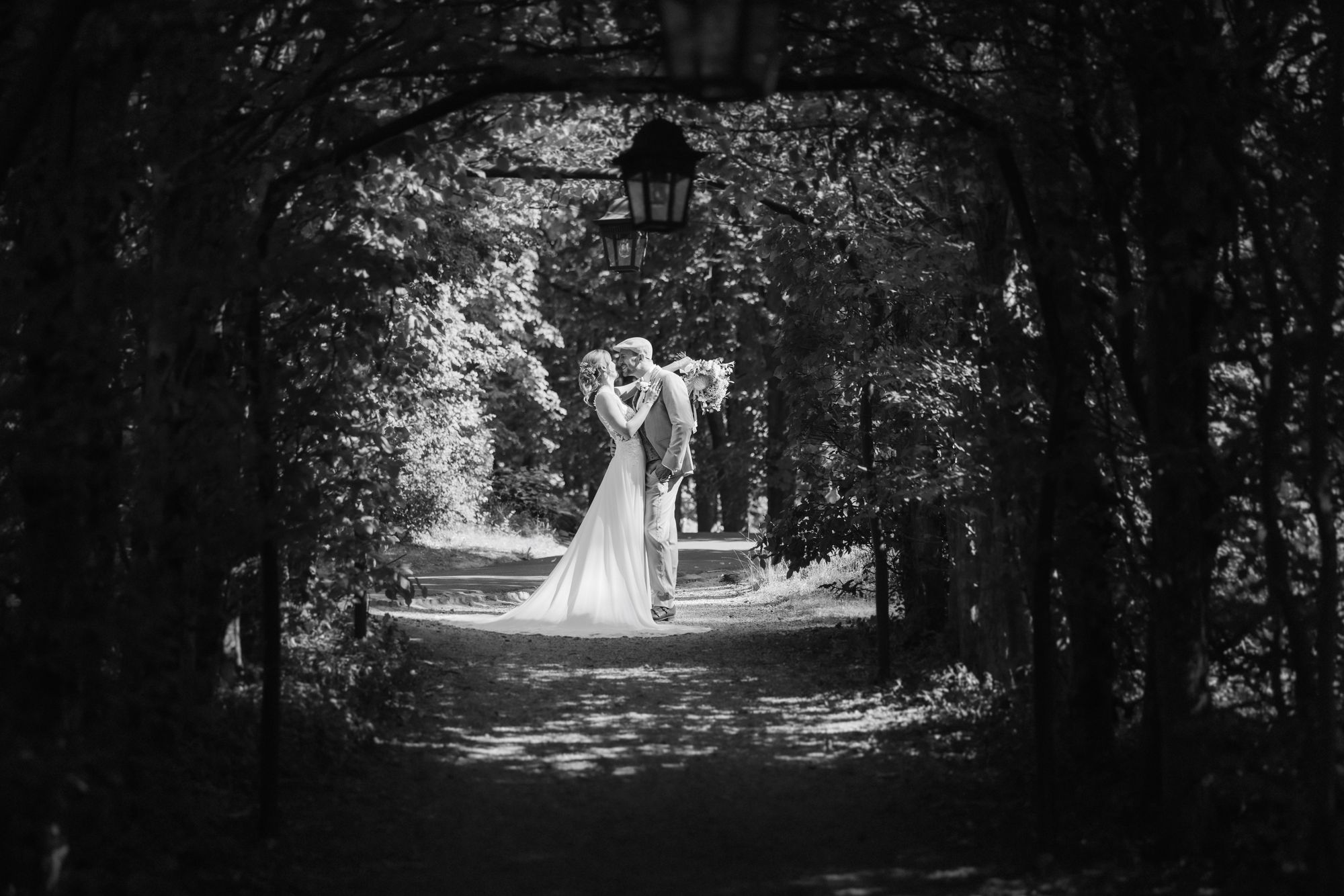 Couple in the tree lined avenue of the castle park in black and white