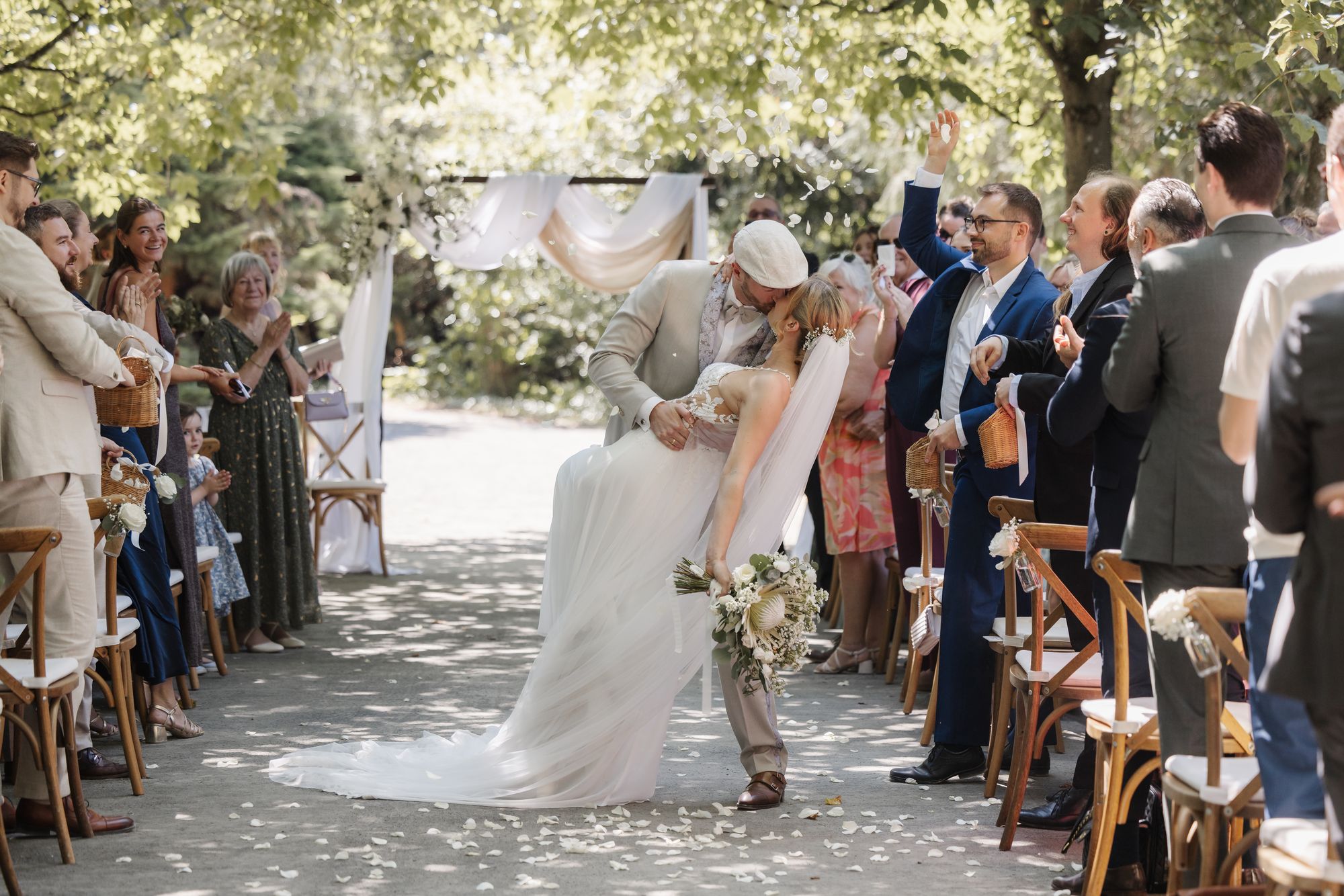 Couple kissing as they walk back down the aisle between their guests