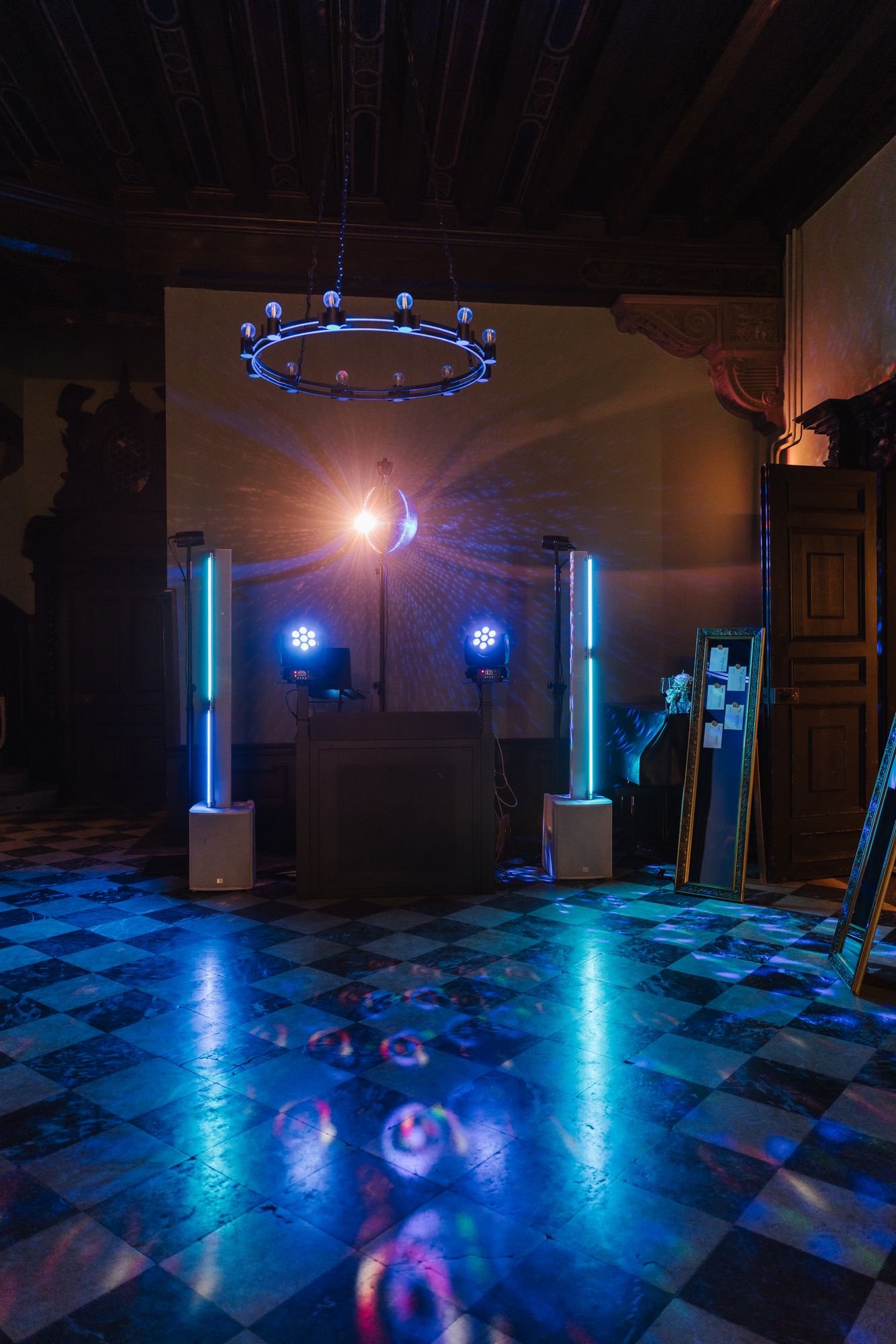 DJ setup with blue lights on the checkerboard floor in the hall