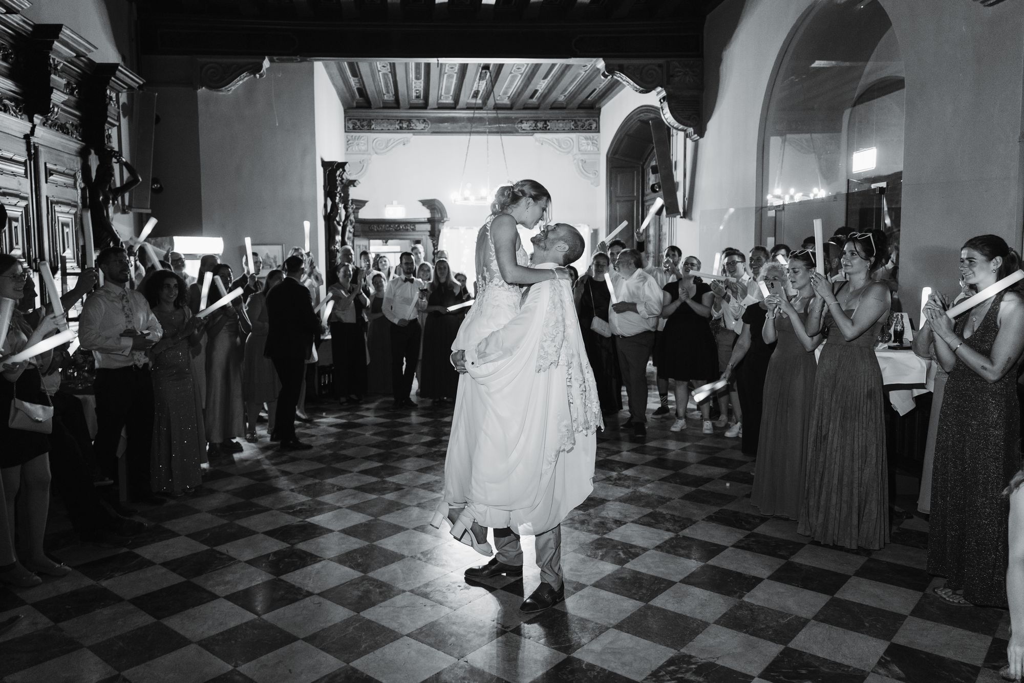 Groom lifting the bride during the first dance, black and white