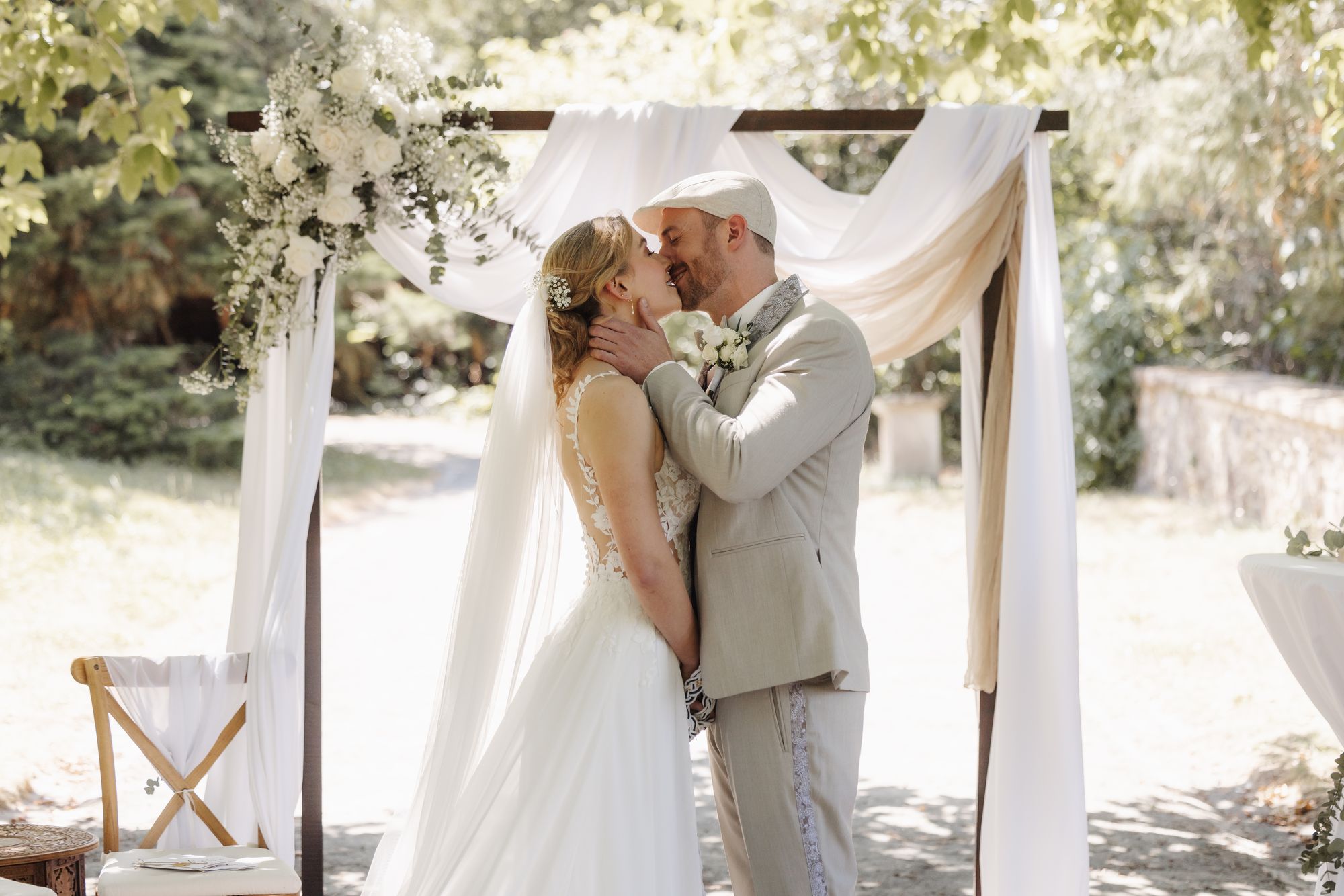 First kiss under the ceremony arch in the castle park