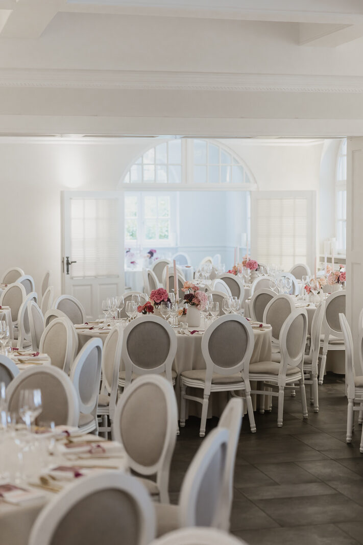 Hochzeitssaal mit Bogenfenstern und eingedeckten runden Tischen auf dem Hohen Darsberg