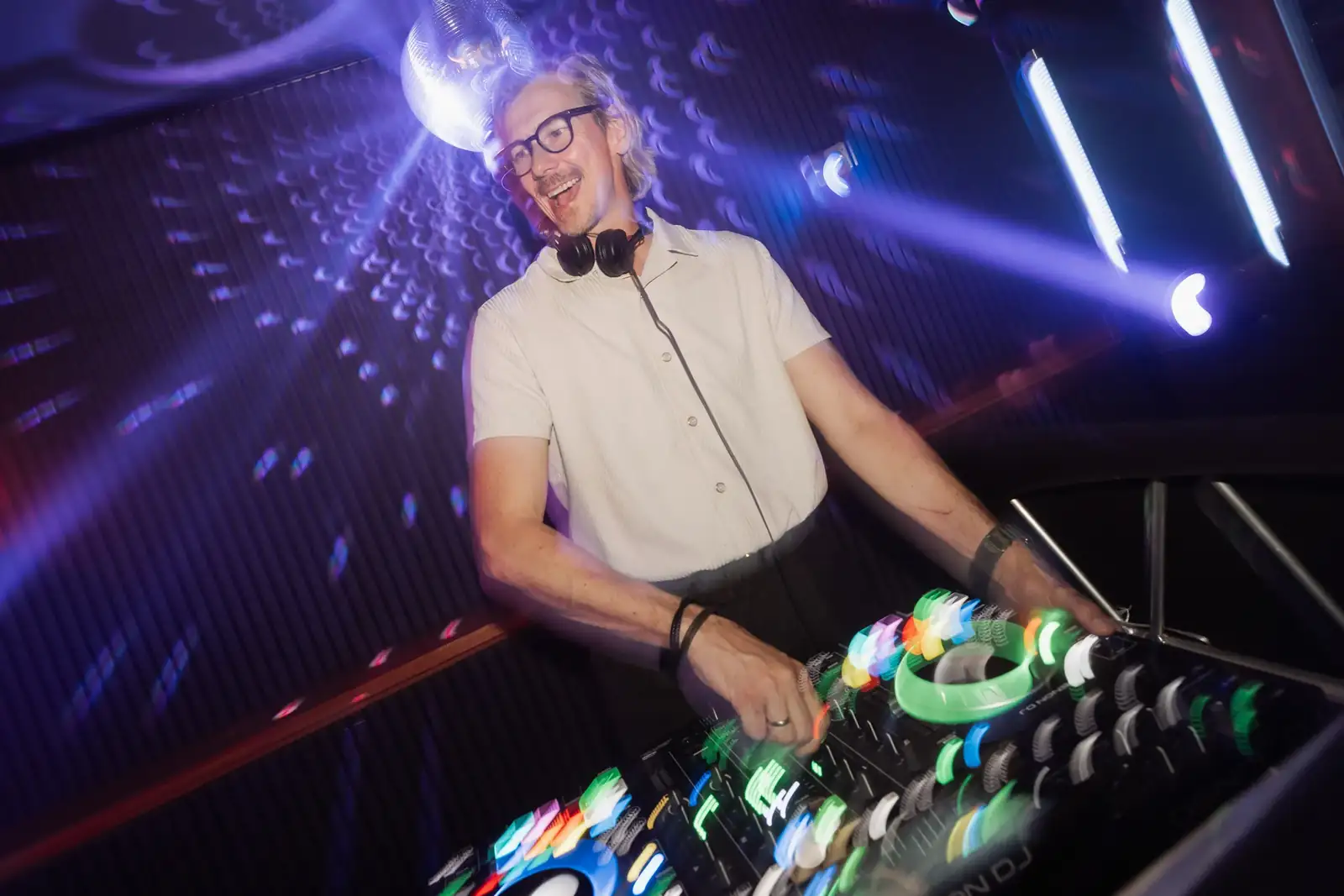 Alex at the DJ booth under the disco ball